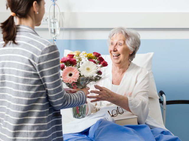patient in hospital receiving flowers from family