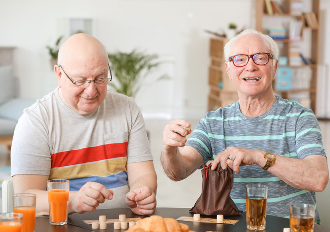 older men playing games in care home together
