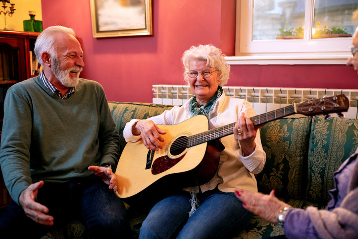 older woman with guitar in care home 