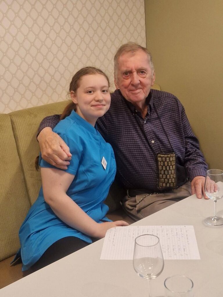 resident and carer doing a quiz smiling