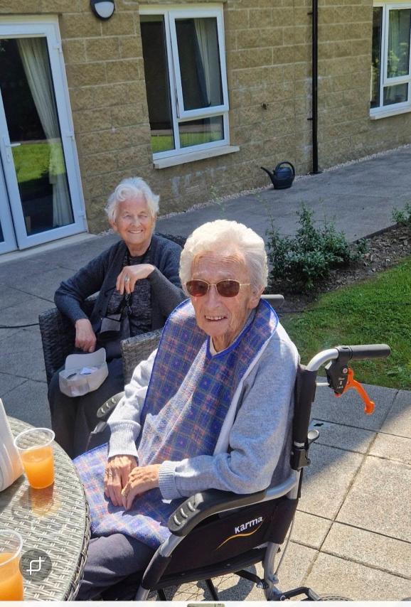 residents in the garden enjoying the weather and the bbq
