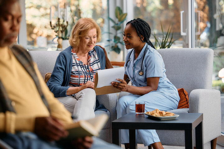 resident and a nuse in a residential care home talking.