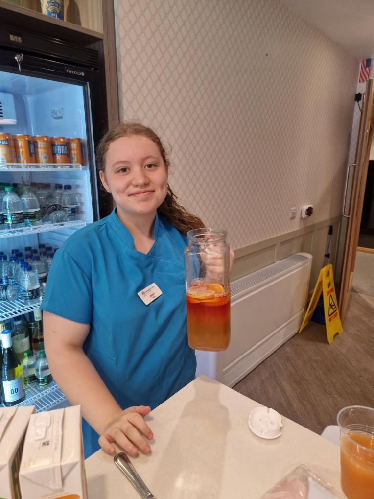 staff holding up juice smiling