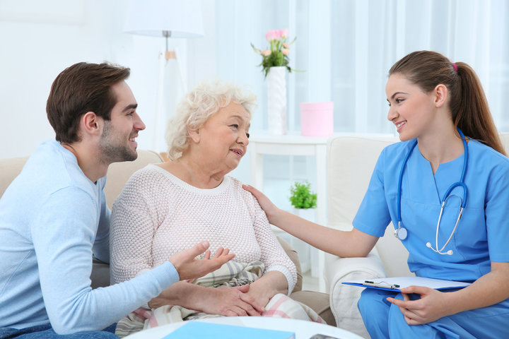nurse talking to a resident and her grandson during a visit in a care home