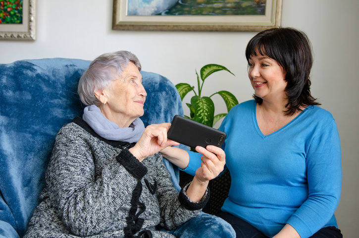 family member visiting loved one in care home on sofa smiling